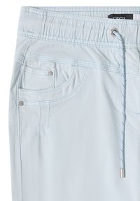 Pantalon bleu clair avec une ceinture élastique, des poches avant et un cordon de serrage avec embouts métalliques sur un fond blanc.