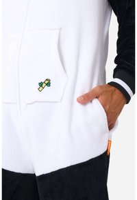 Monopieza de forro polar en blanco y negro con un bolsillo frontal, que presenta un bordado de bambú. Incluye puños acanalados y un cierre de cremallera.
