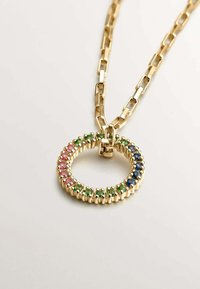 Collar de cadena de oro con un colgante circular decorado con piedras preciosas de colores rosa, verde y azul, engastadas en un marco texturizado.