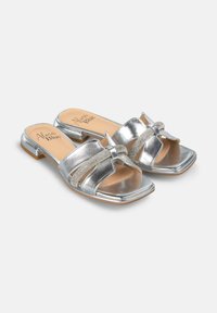 Metaalachtige zilveren instapsandalen met een plat hakje, voorzien van een decoratieve strik en kristalaccenten op de banden, met een vierkante neus.