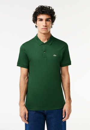 Polo verde realizzata in tessuto testurizzato, con colletto classico, tre bottoni e un piccolo logo ricamato sul lato sinistro del petto.