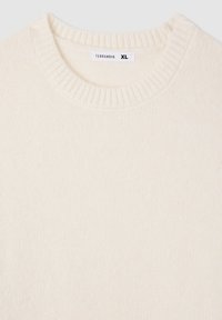 Kremowy sweter dzianinowy z okrągłym, prążkowanym dekoltem, o miękkiej strukturze, z metką z napisem "Terranova XL" blisko kołnierza.
