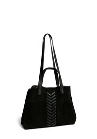 Sac fourre-tout en suède noir avec des poignées en cuir et un design zigzag texturé à l'avant, présentant une doublure intérieure à pois.