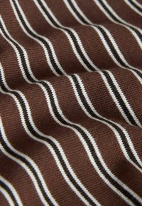 Brown knitted fabric with evenly spaced vertical white and black thin stripes creating a repeating pattern.