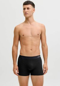 Black boxer briefs made of a soft, stretch fabric with a solid design. Features a wide waistband with brand logo detail.