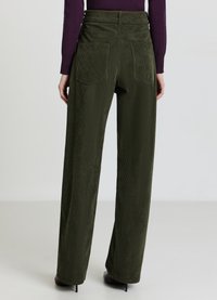 Pantaloni a gamba larga in velluto a coste color verde oliva con vita alta, dotati di due tasche posteriori e un motivo a strisce verticali testurizzate.