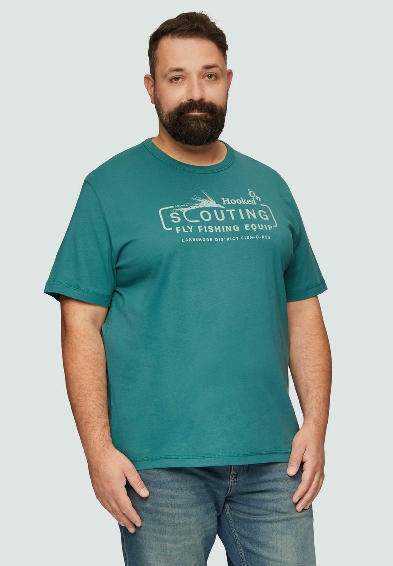 Turkusowa bawełniana koszulka z okrągłym dekoltem, krótkimi rękawami i nadrukowanym tekstem "Hooked On Scouting Fly Fishing Equip" na białym tle. Luźny krój.