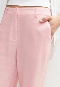 Lichtroze linnen broek met een rechte pasvorm, zijzakken en een gladde textuur. Inclusief riemlussen en een platte voorkant.
