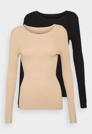 Dva žebrované svetry s dlouhým rukávem a kulatým výstřihem, jeden v béžové barvě umístěný před černým, vystavené na jednobarevném pozadí.