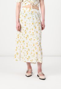 Bloemen midi-jurk in het wit met gele en groene patronen, gemaakt van textuurstof; heeft een elastische tailleband voor comfort.