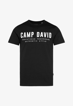 Czarna bawełniana koszulka z okrągłym dekoltem. Na przodzie widnieje pogrubiony biały napis: „CAMP DAVID ZAREJESTROWANY ZNAK TOWAROWY AUTENTYCZNY STYL”.