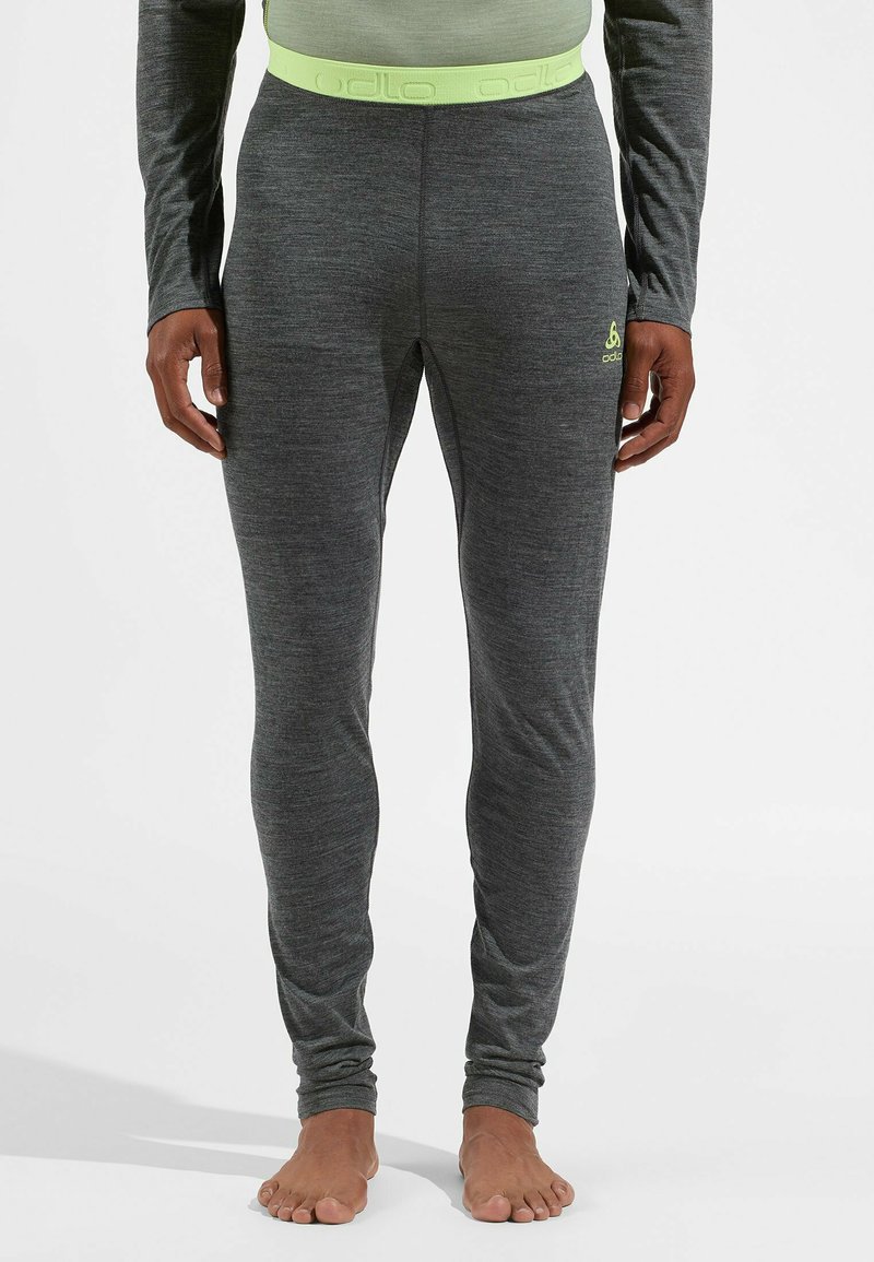 Graue Sportleggings mit einer weichen Textur, enganliegendem Design und einem hellgrünen Odlo-Logo am linken Oberschenkel; elastischer Bund in passender Farbe.