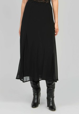 Jupe maxi noire fluide en tissu léger, avec une texture lisse et un mouvement subtil, associée à des bottes noires jusqu'aux genoux.