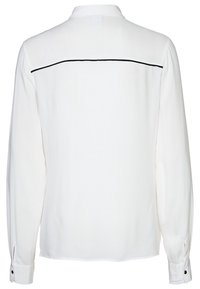 Bílá košile s dlouhým rukávem z hladké látky, s klínem na zádech zdobeným černou linkou a manžetami na knoflíky. Jednoduchý límec.