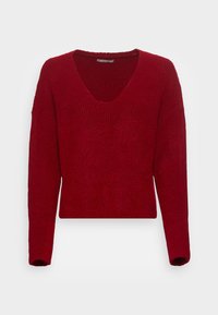 Pull en maille rouge à manches longues avec col en V et texture côtelée, présenté sur un fond blanc uni.