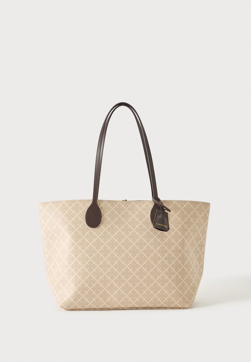 Sac fourre-tout beige avec un léger motif quadrillé, anses en cuir marron foncé et une petite étiquette attachée sur fond blanc.