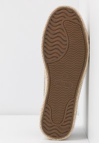 Suola in gomma marrone con un motivo ondulato, bordata in juta beige. Etichetta del marchio "ANNA FIELD" e taglia "37" visibili vicino al centro.