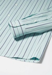 Chemise bleu clair à fines rayures verticales sombres, avec un poignet boutonné et des boutons blancs le long du devant.