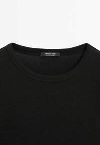 Sort t-shirt med rund halsudskæring, synlige syninger og en label med teksten "Massimo Dutti Made in Portugal" inde i kraven.