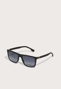 Ochelari de soare rectangulari negri cu lentile întunecate în degrade. Finisaj mat, accente din metal pe balamale și design elegant. Fără logo-uri vizibile.