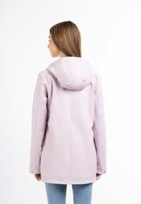 Lichtroze waterdichte jas met een capuchon, lange mouwen en drukknoopsluiting, met een gladde textuur en een eenvoudig ontwerp.