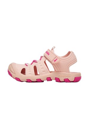 Jasnoróżowy i magentowy sandał dziecięcy Reebok z regulowanym paskiem, odkrytymi bokami i fakturowaną podeszwą.