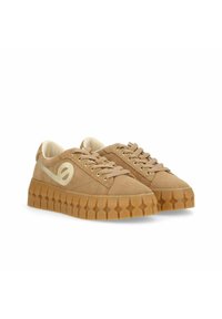 Tan suede sneakers with a textured rubber sole, rounded toe, and cream-colored accents. Features flat laces and gold eyelets.