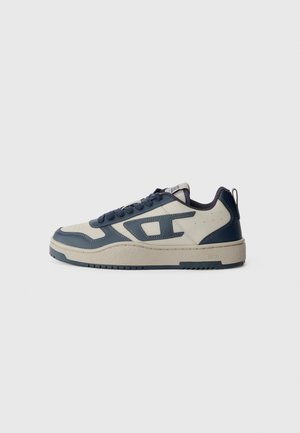 Sneaker da uomo caratterizzato da una tomaia in pelle blu navy e crema, dettagli testurizzati, suola spessa e lacci scuri. Dettaglio del logo sul tallone.