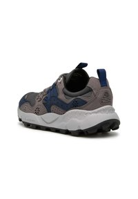 Scarpa sportiva grigia e blu navy con tomaia testurizzata, occhielli rinforzati, suola bianca ammortizzata e accenti blu sul tallone e sui lacci.