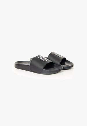 Paire de sandales noires Puma avec larges brides et logo Puma sur chaque bride, présentées sur fond blanc.
