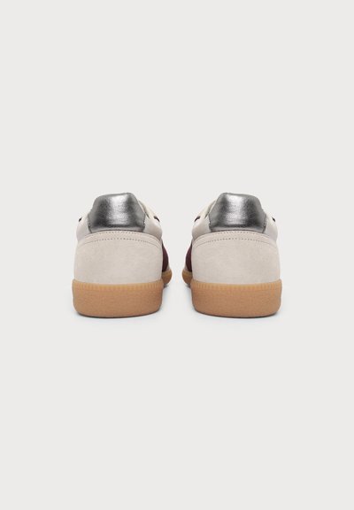 Ζευγάρι χαμηλά sneakers με μπεζ σουέντ πίσω μέρος, μεταλλικό ασημί τακούνι, βουργουνδί πλευρές και ανοιχτό καφέ σόλες από καουτσούκ, εμφανίζονται από πίσω.