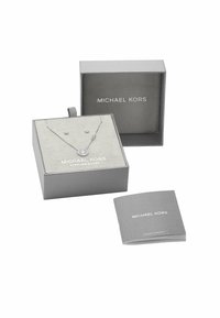 Collana in argento sterling con pendente rotondo e accento a stella in una scatola regalo grigia. Include un libretto di garanzia, la scatola presenta un logo impresso.