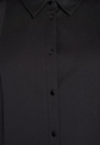 Zwarte shirt met een kraag en zes knopen aan de voorkant, met een gladde stofstructuur en subtiele glans.