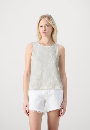 Top sin mangas de color gris claro con tejido texturizado y un sutil patrón floral, combinado con pantalones cortos blancos desgastados. Diseño minimalista.