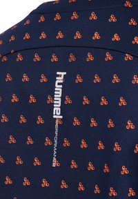 Marinblå sporttröja med texturerat tyg som har orangea, fjärilslika mönster och "hummel PERFORMANCE"-logotyp i vitt på sidan.