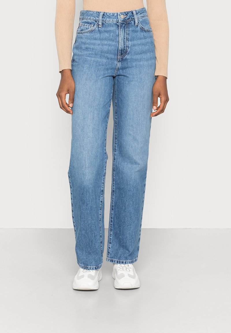Jean bleu clair taille haute avec une coupe droite, en tissu denim. Comprend des coutures contrastées et un style cinq poches.