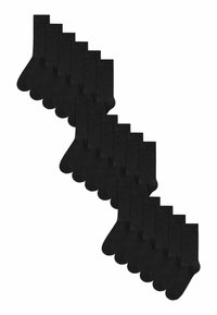Chaussettes noires en coton disposées dans un motif décalé, d'une longueur standard, avec une texture lisse et un design minimaliste.