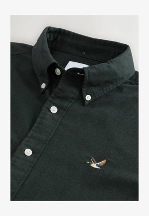 Mörkgrön knäppt skjorta med krage, försedd med vita knappar och en liten broderad ankdesign på bröstet.