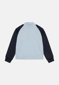 Helevarrukatega pullover helesinise kere ja tumesiniste varrukatega, püstkraega, soonikkoes mansettide ja vöökohaga, laidlina asetatud näoga alla.