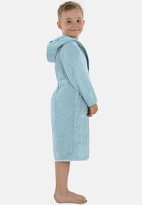 Helles blaues, weiches Frottee-Bademantel mit Kapuze, Gürtel in der Taille und seitlichen Taschen. Für Kinder entworfen, knielang mit strukturiertem Stoff.