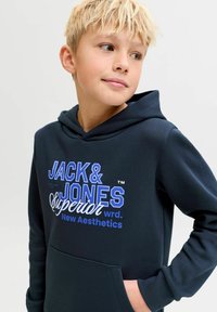 Sudadera con capucha azul marino hecha de tela suave con texto audaz en blanco y azul. Incluye un bolsillo frontal y una capucha grande. Diseño simple y moderno.