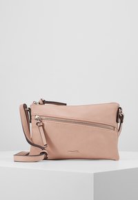 Světle růžová kožená crossbody taška s diagonálním předním zipovým kapsou a nastavitelným popruhem, umístěná na bílé ploše.