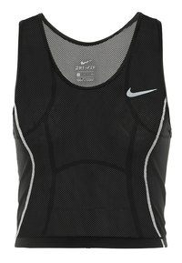 Crop top de sport noir avec une texture en maille, doté d'un col rond, d'accents blancs sur les côtés et d'un logo Nike sur le devant.