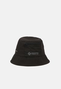 Svart bøttehatt laget av vannavstøtende materiale, med en glidelåslomme og "WINDSTOPPER"-merking i hvitt. Teksturert brem og kropp.