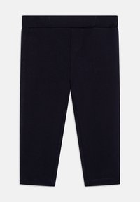Marineblaue Baumwollleggings mit einem elastischen Bund, die zwei Fake-Taschen und kontrastierende Nähte aufweisen. Klassische Passform ohne Muster.