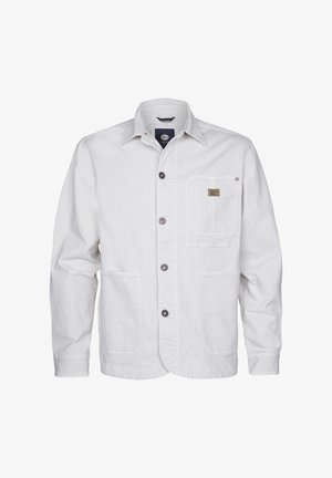 Witte katoenen jas met een knoopsluiting aan de voorkant, twee voorzakken en een borstzak met een label. Zachte textuur en een ontspannen pasvorm.