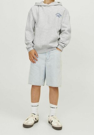 Sweat à capuche gris avec poignets côtelés, logo bleu, short en jean clair, chaussettes blanches et noires, et baskets beiges avec accents noirs.