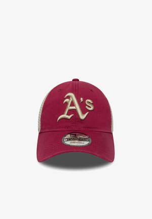 Red cap with beige mesh sides, featuring embroidered "A's" logo in gold. Adjustable design, classic structured shape, and textured fabric.