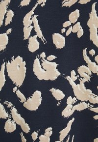 Ciemny materiał z beżowym abstrakcyjnym wzorem zwierzęcym. Tekstura jest gładka, z dzianinowym wyglądem i różnorodnymi wzorami pociągnięć pędzla.