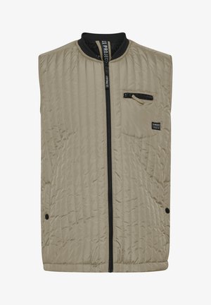 Paimeninė smėlinė liemenė su juodu užtrauktuku ir apykakle. Yra šoninis kišenė su užtrauktuku ir mažas logotipas ant krūtinės.